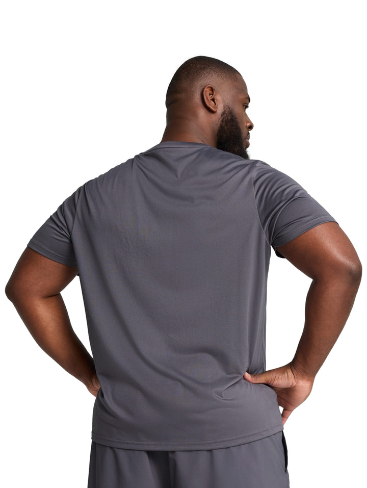 Hombre vistiendo una camiseta deportiva de color gris oscuro de la marca PUMA con cuello redondo y manga corta.