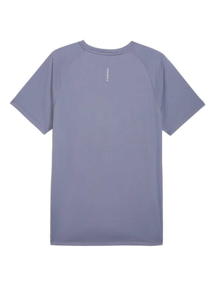 Hombre vistiendo camiseta deportiva PUMA color plata vibrante sobre una prenda negra de manga larga.