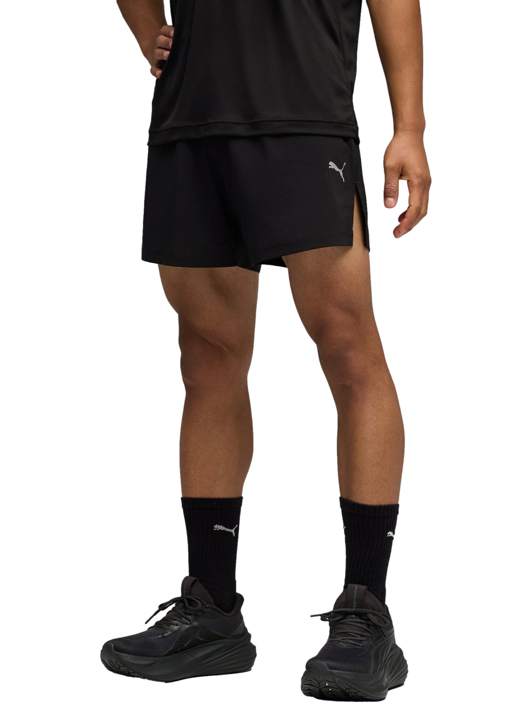 Hombre vistiendo shorts deportivos PUMA color negro con logo blanco en la pierna izquierda.
