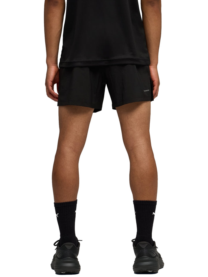 Hombre vistiendo shorts deportivos PUMA color negro con logo blanco en la pierna izquierda.