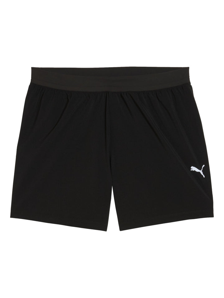 Hombre vistiendo shorts deportivos PUMA color negro con logo blanco en la pierna izquierda.