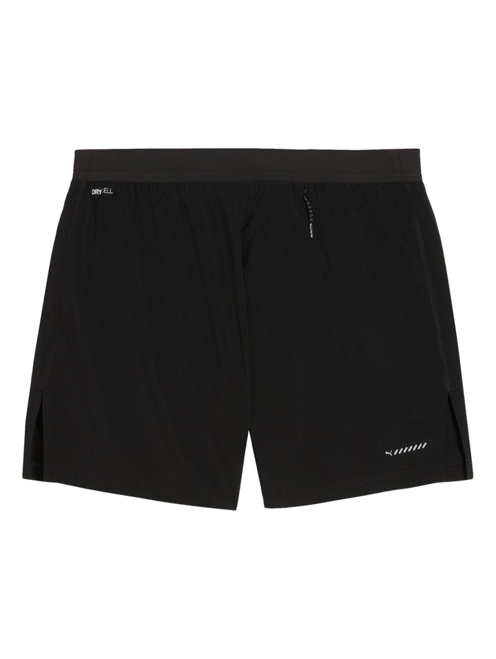 Hombre vistiendo shorts deportivos PUMA color negro con logo blanco en la pierna izquierda.