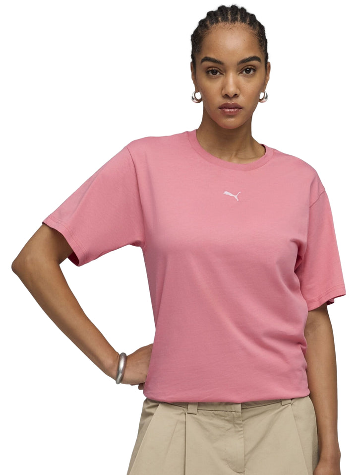Mujer vistiendo playera PUMA color rosa intenso con corte relajado y cuello redondo.