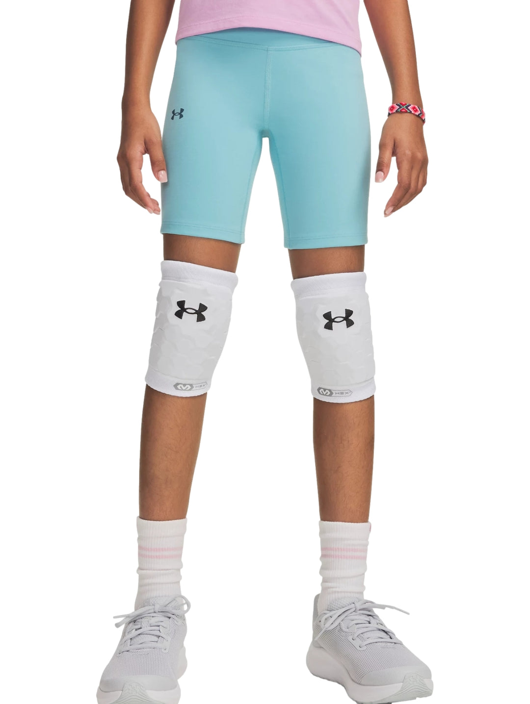 Mujer vistiendo pantalones cortos tipo biker de color azul claro de la marca Under Armour.