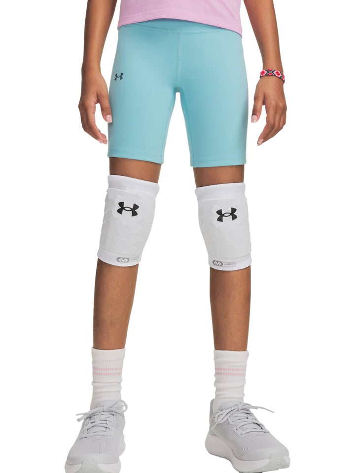 Mujer vistiendo pantalones cortos tipo biker de color azul claro de la marca Under Armour.