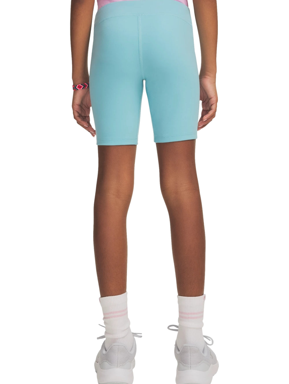 Mujer vistiendo pantalones cortos tipo biker de color azul claro de la marca Under Armour.