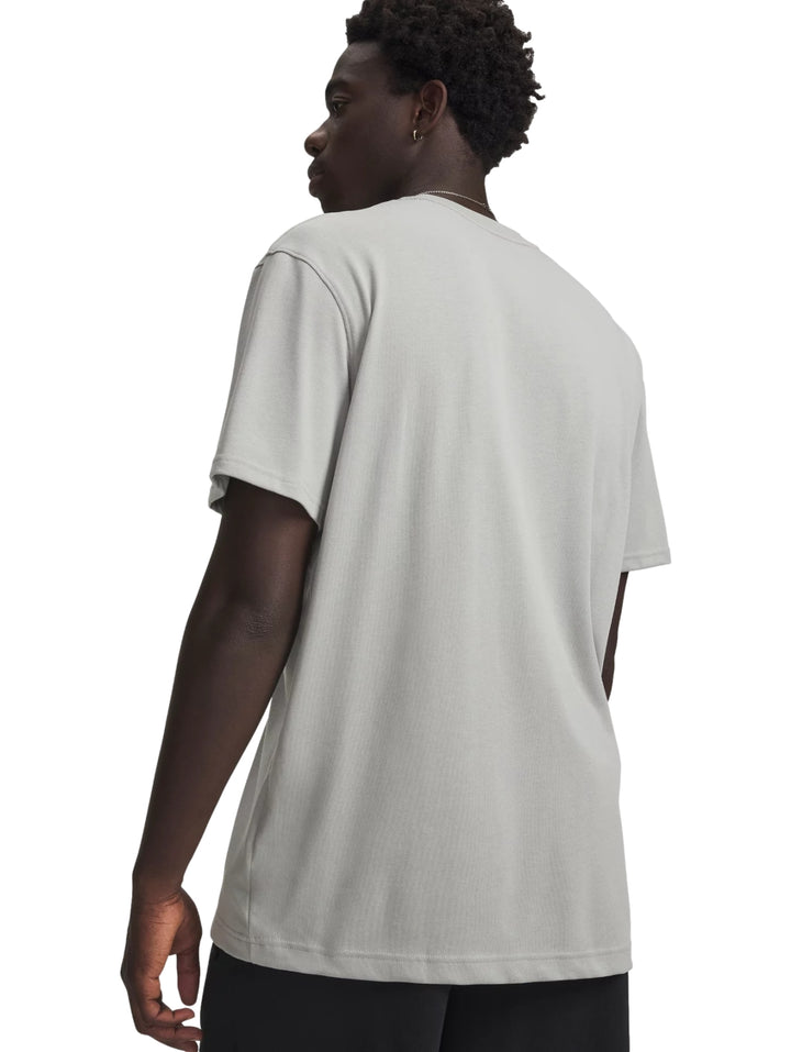 Hombre vistiendo una playera de manga corta color gris con logotipo de Under Armour en el pecho.