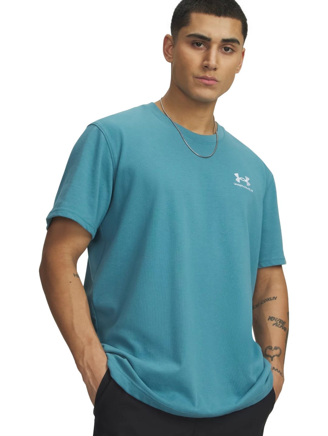 Hombre vistiendo una playera deportiva de manga corta color azul con logo blanco en el pecho.