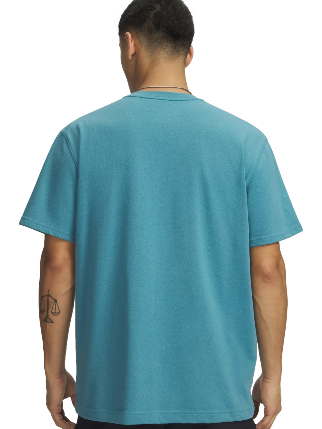 Hombre vistiendo una playera deportiva de manga corta color azul con logo blanco en el pecho.
