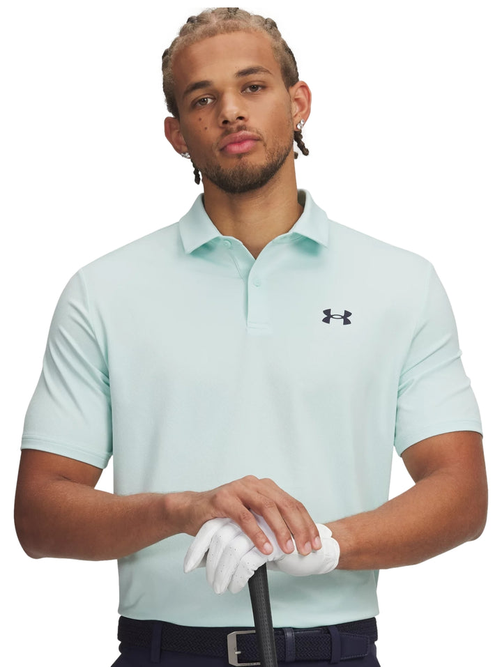 Hombre vistiendo una playera polo deportiva de color verde menta de la marca Under Armour.