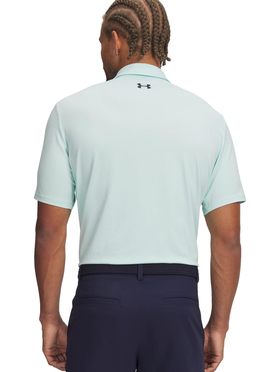 Hombre vistiendo una playera polo deportiva de color verde menta de la marca Under Armour.