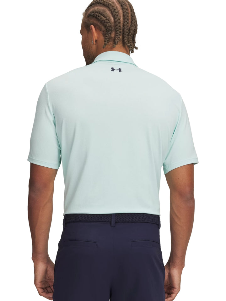 Hombre vistiendo una playera polo deportiva de color verde menta de la marca Under Armour.