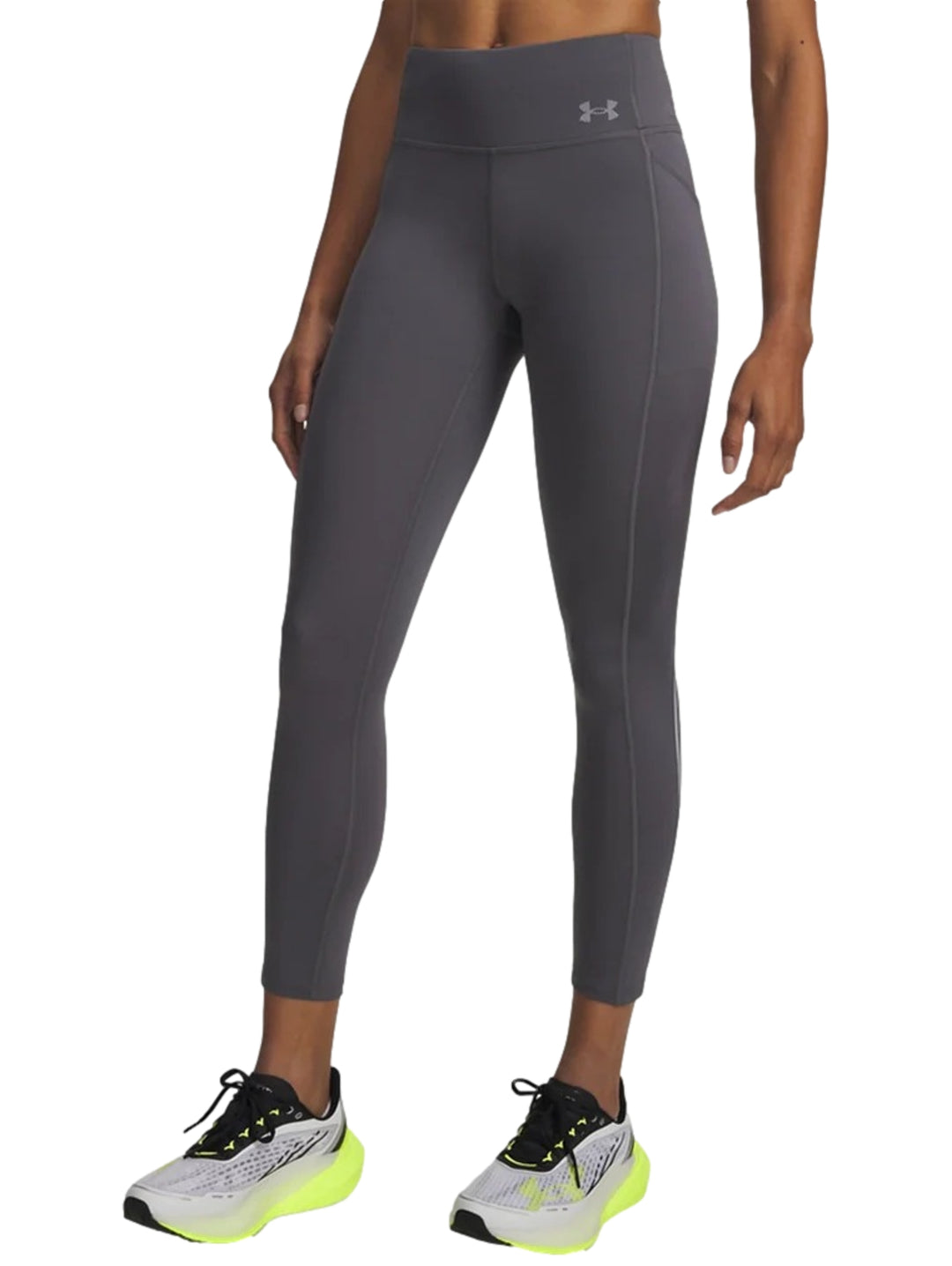 Mujer vistiendo mallas deportivas Under Armour de color gris, ajustadas y de largo al tobillo.