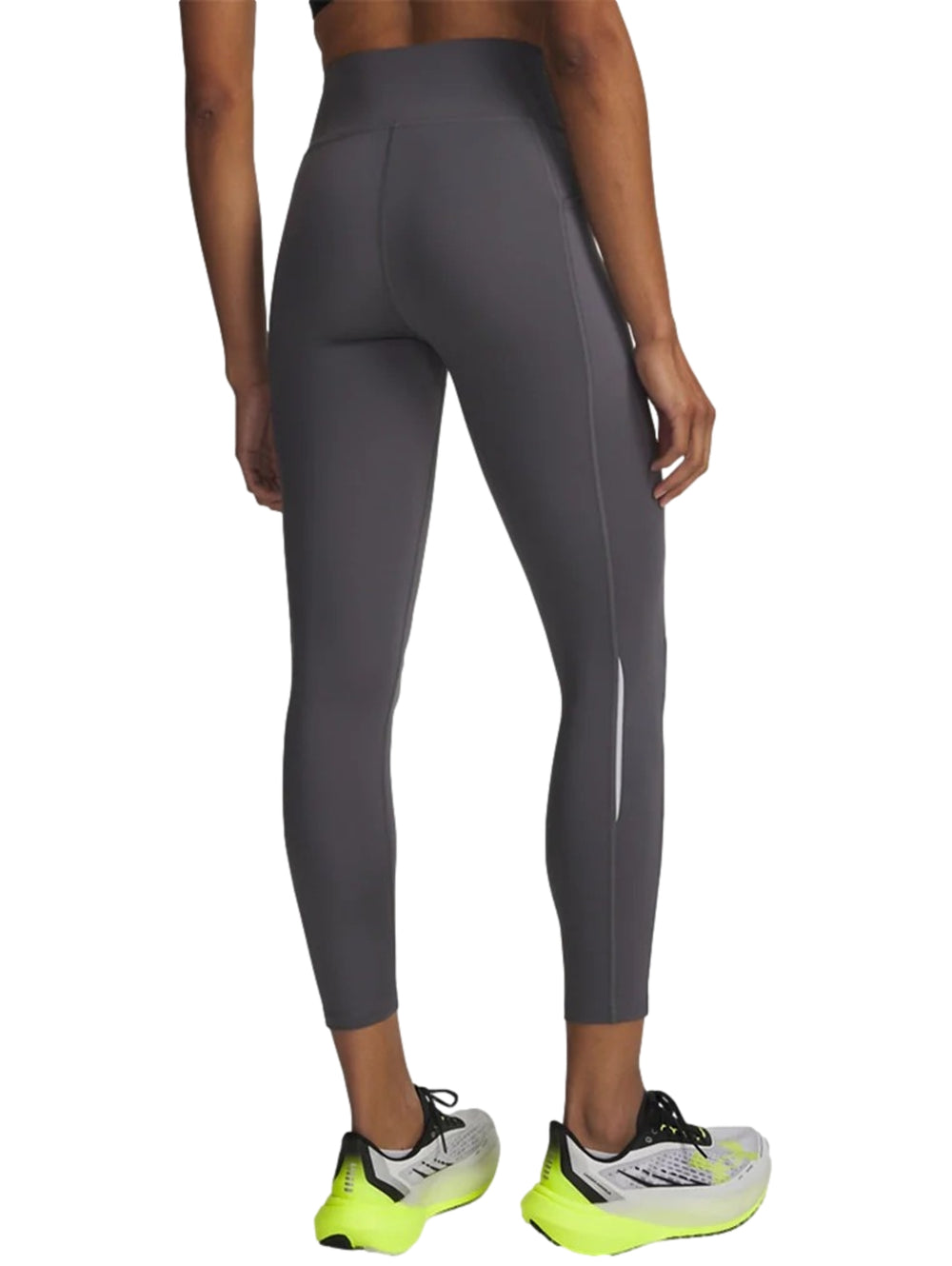 Mujer vistiendo mallas deportivas Under Armour de color gris, ajustadas y de largo al tobillo.
