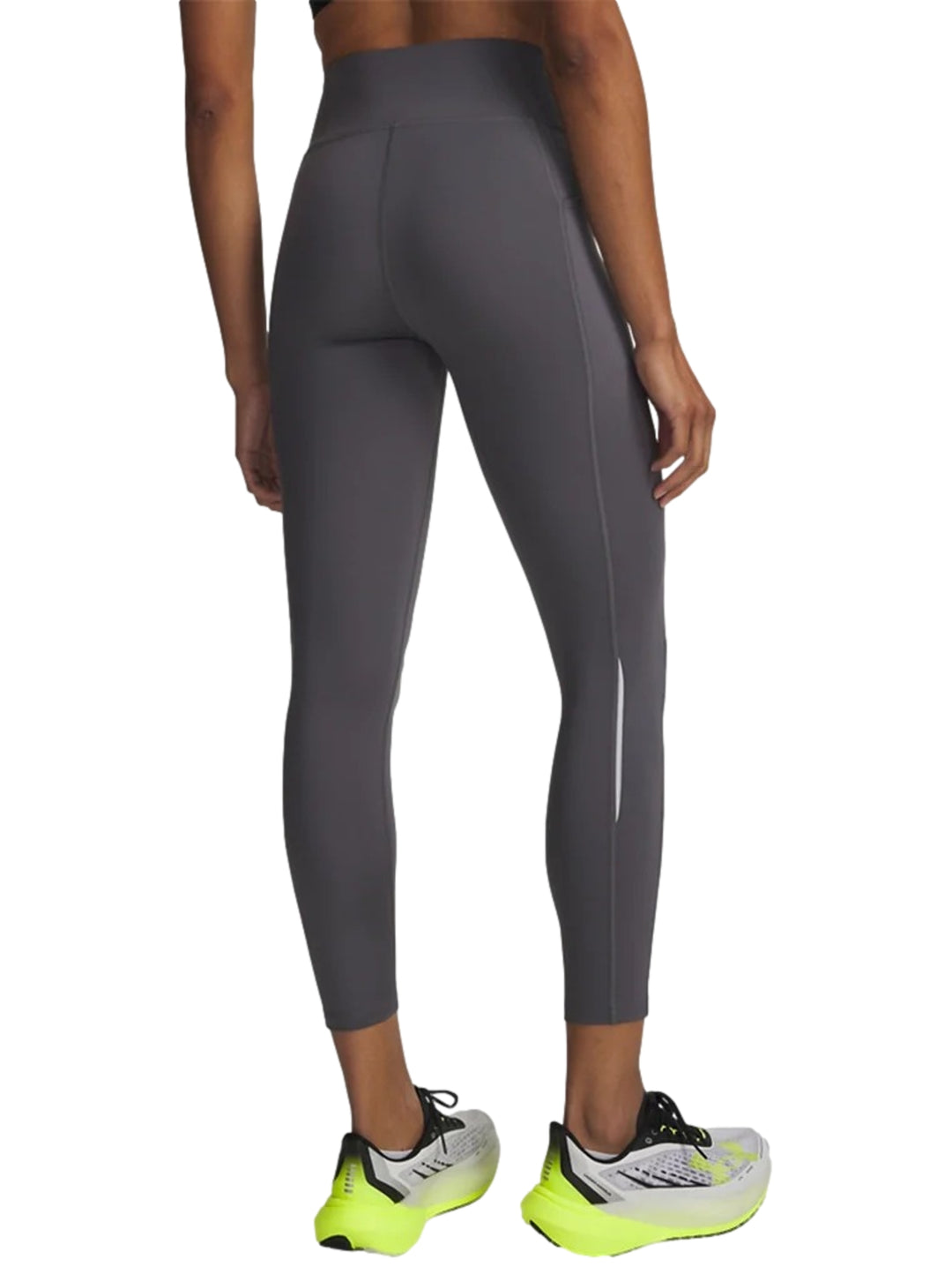 Mujer vistiendo mallas deportivas Under Armour de color gris, ajustadas y de largo al tobillo.