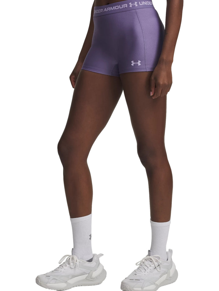 Mujer vistiendo shorts deportivos ajustados de color morado de la marca Under Armour.