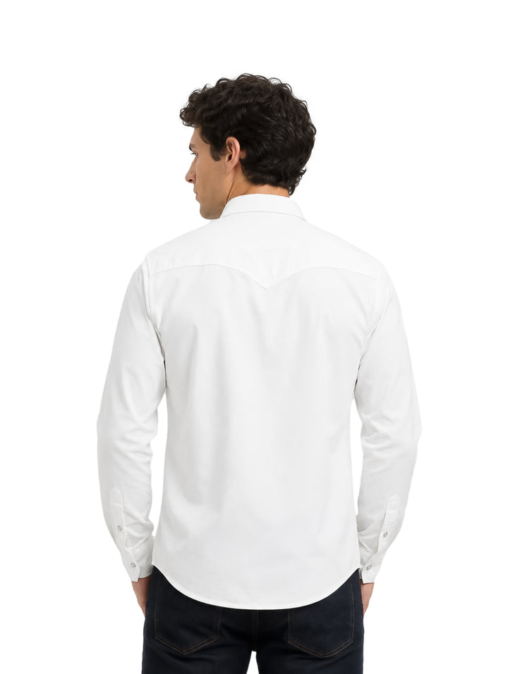 Hombre vistiendo una camisa blanca de manga larga con botones y bolsillos frontales.