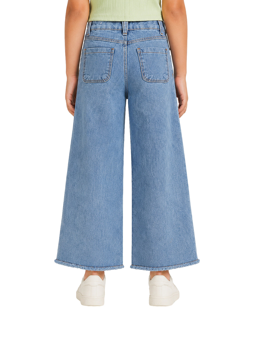 Jeans azules de pierna ancha para niña con bajos deshilachados.