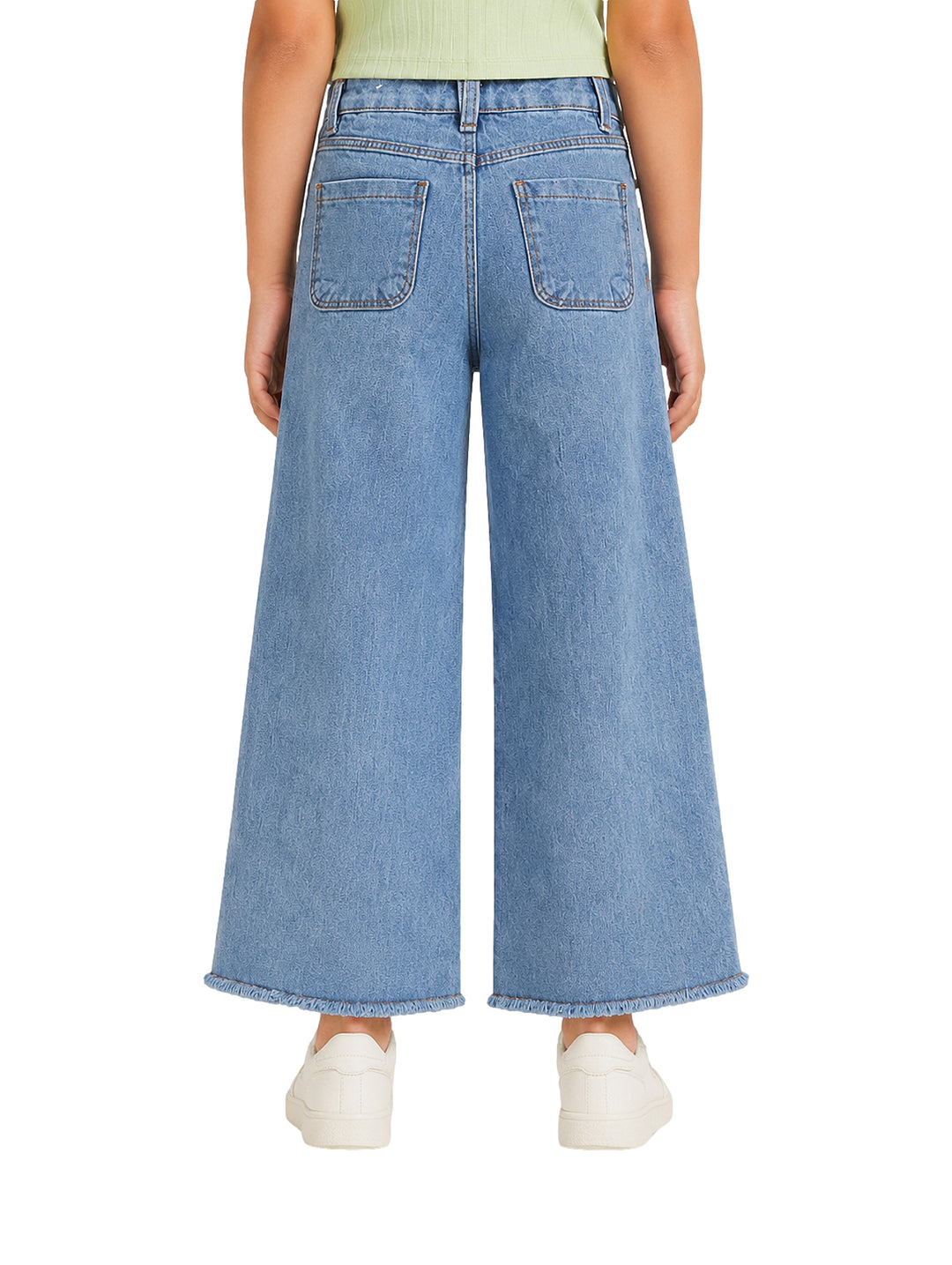 Jeans azules de pierna ancha para niña con bajos deshilachados.