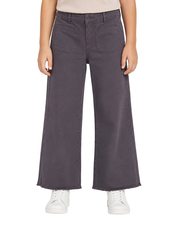 Pantalón gris oscuro de pierna ancha para niña con bolsillos frontales y borde deshilachado.