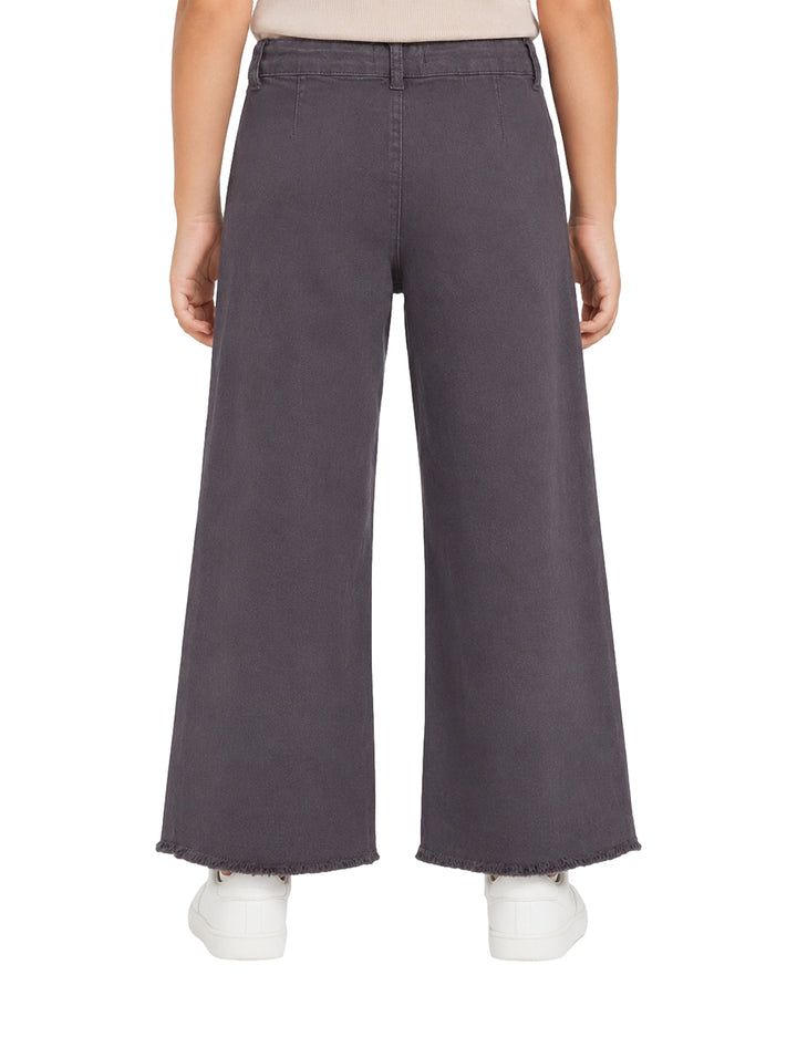 Pantalón gris oscuro de pierna ancha para niña con bolsillos frontales y borde deshilachado.