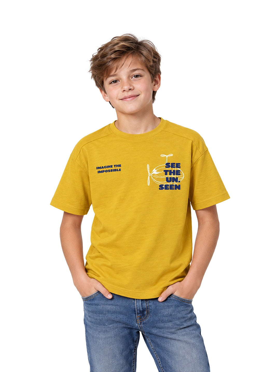 Niño vistiendo playera Zippy color amarillo oscuro con estampado gráfico en el pecho y pantalones de mezclilla.