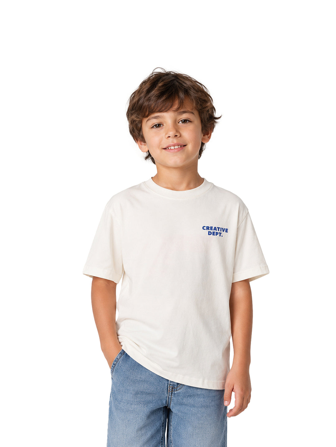 Niño vistiendo una playera blanca de manga corta con texto azul en el pecho y pantalones de mezclilla azules.
