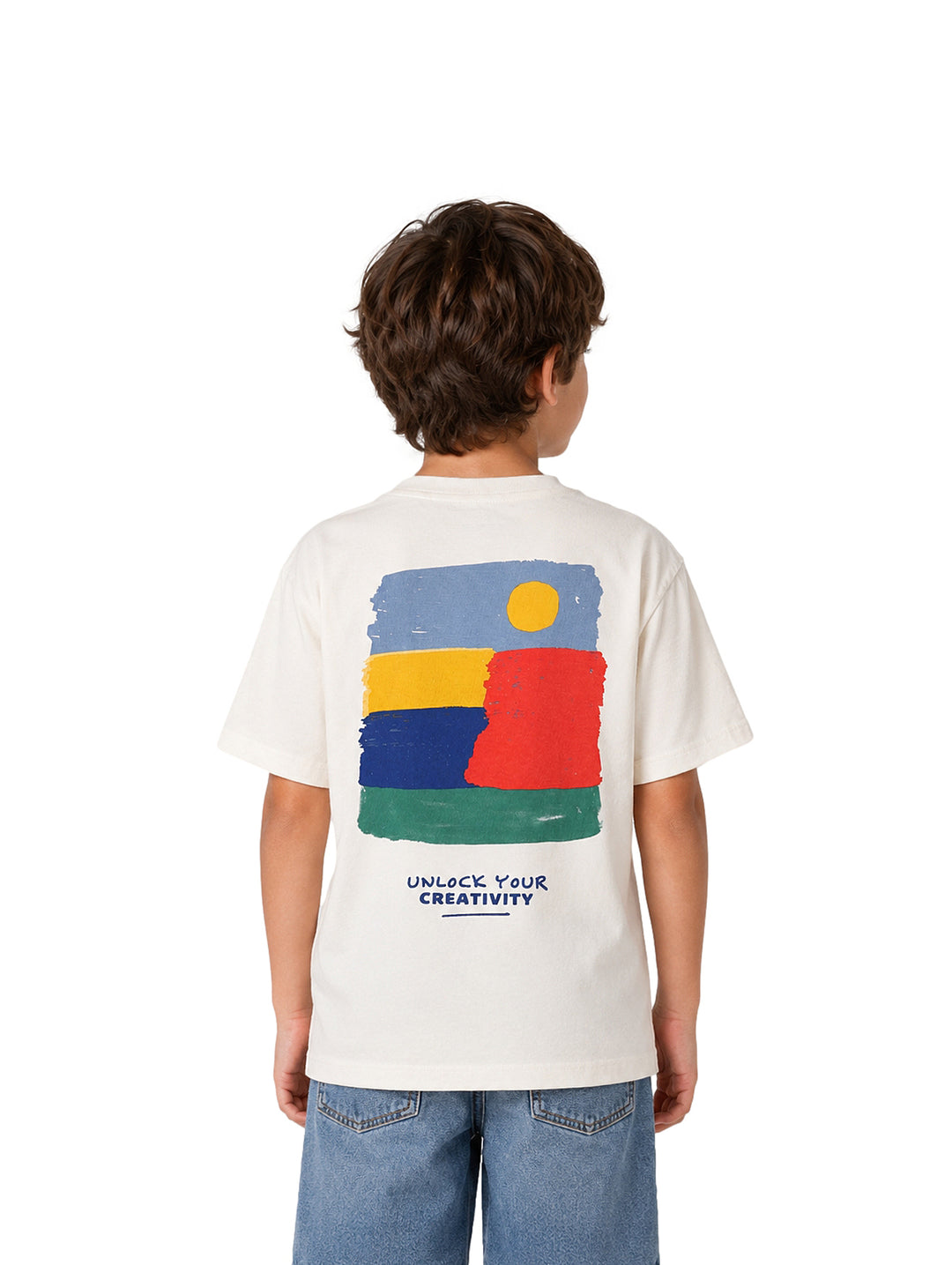 Niño vistiendo una playera blanca de manga corta con texto azul en el pecho y pantalones de mezclilla azules.