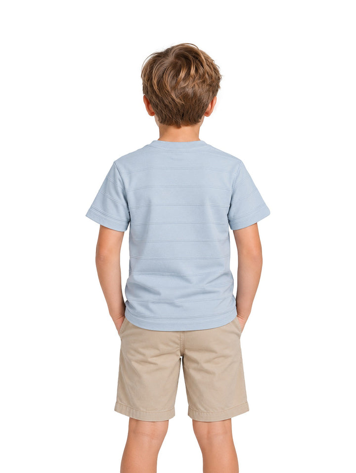 Niño vistiendo playera Zippy azul claro con textura de rayas jacquard y un bolsillo frontal.