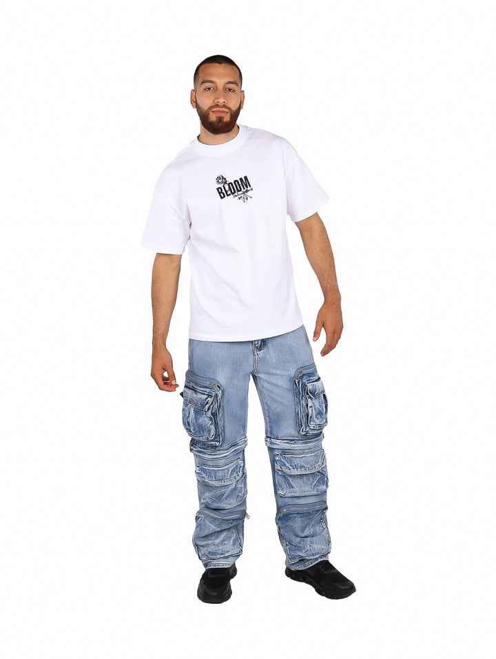 Hombre vistiendo una playera blanca de manga corta con estampado negro en el pecho que dice BLOOM.
