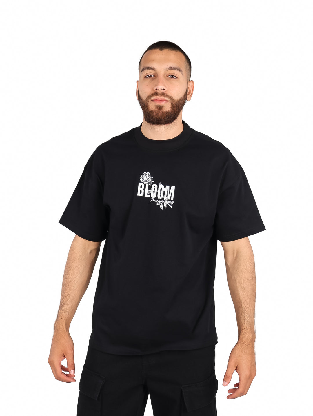 Hombre vistiendo playera color negro de manga corta con estampado blanco en el pecho.