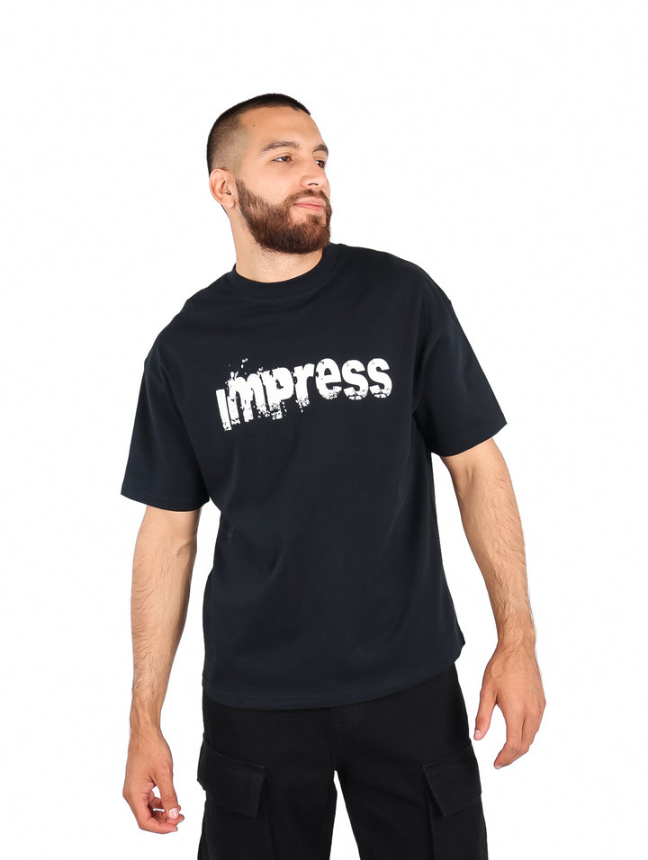 Hombre vistiendo una playera negra de manga corta con el texto &