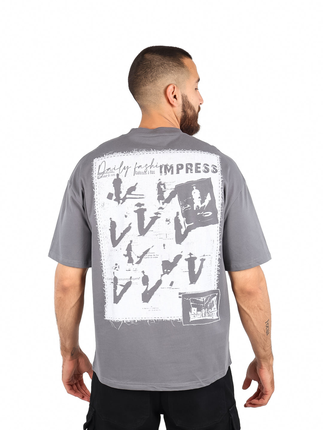Hombre vistiendo una playera gris de manga corta con el texto &