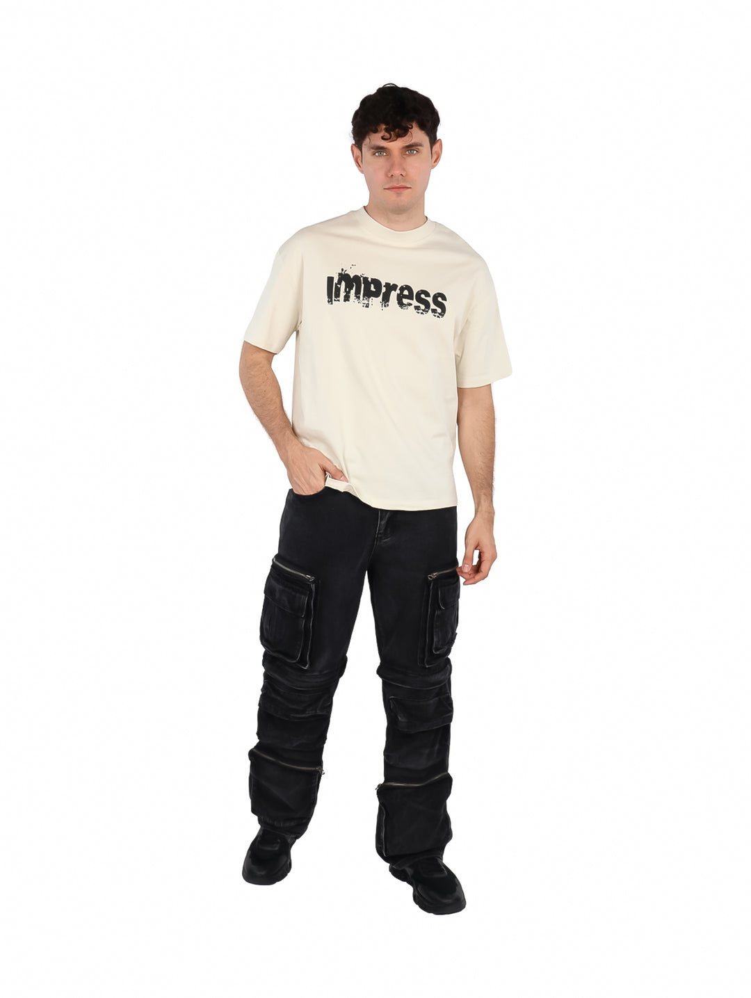 Hombre vistiendo una playera color beige con estampado negro en el pecho.