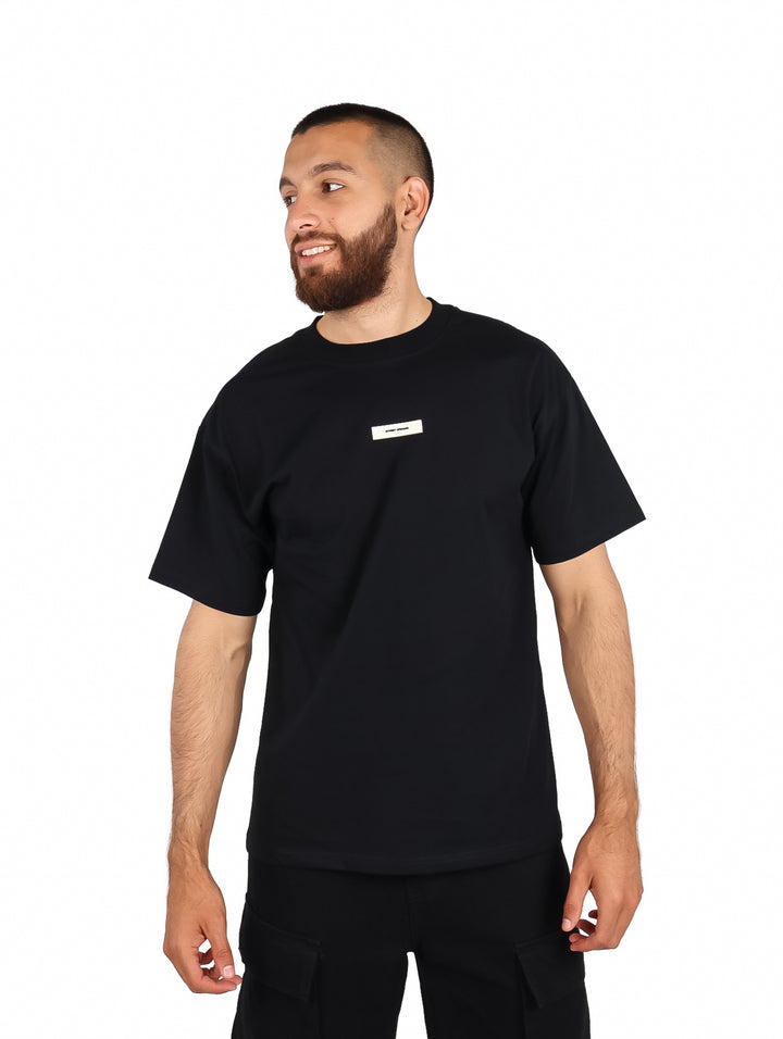 Hombre vistiendo playera FIMONS color negro de manga corta y cuello redondo.