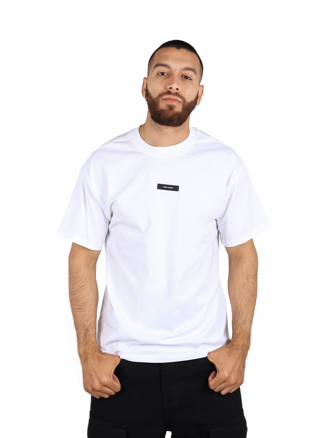 Hombre vistiendo playera blanca de manga corta marca Fimons con cuello redondo.