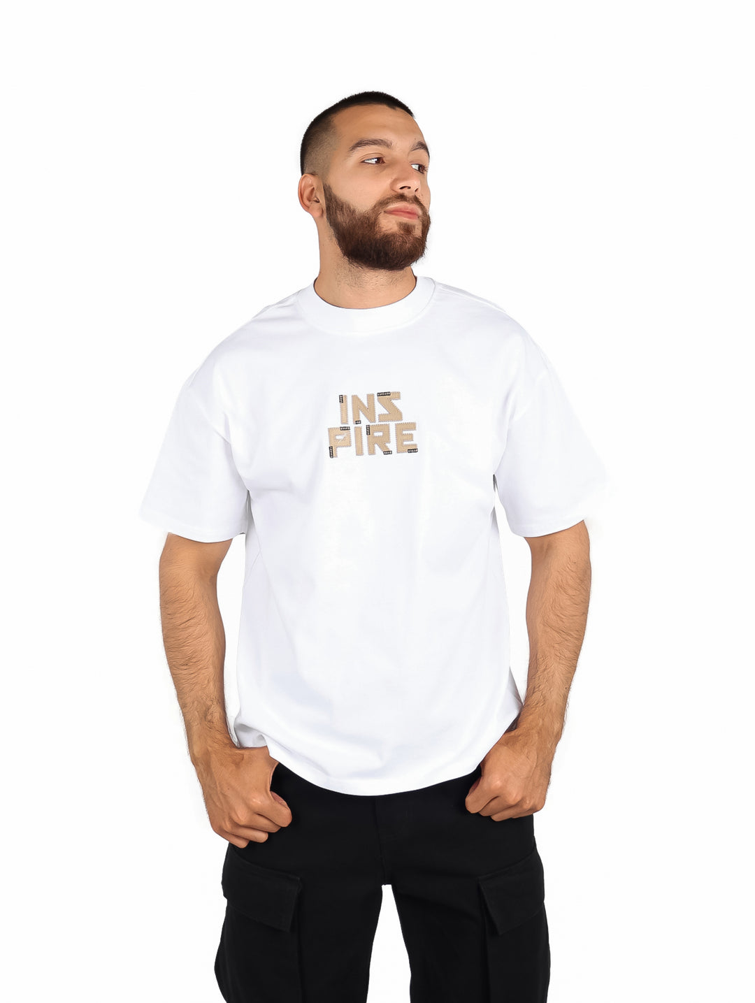 Hombre vistiendo playera blanca de manga corta con estampado 'INSPIRE' en el pecho.