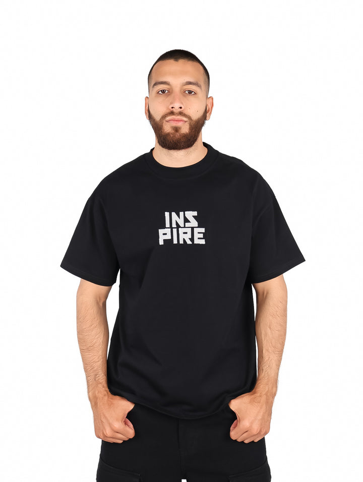 Hombre vistiendo playera negra de manga corta con estampado blanco &