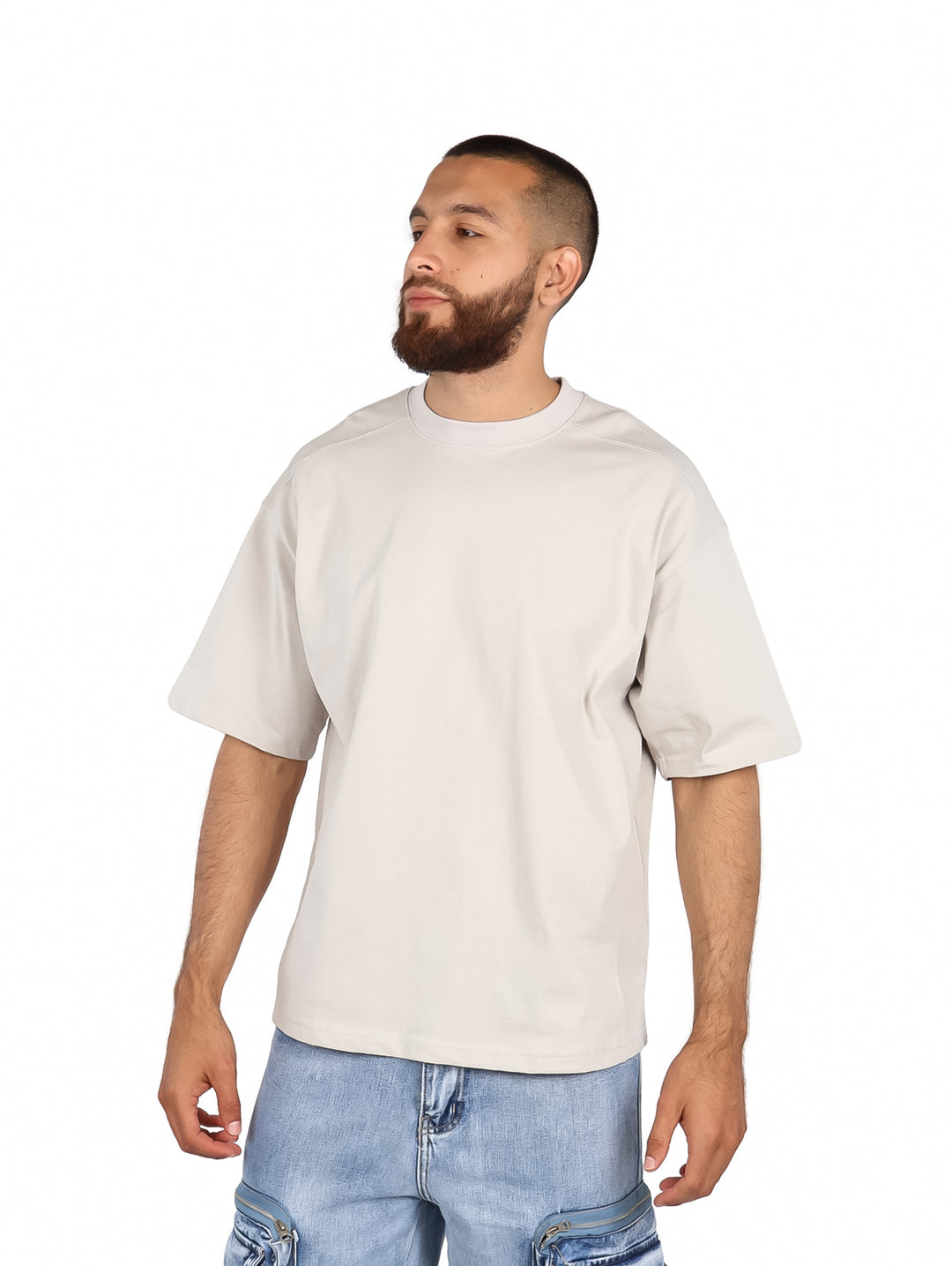Hombre vistiendo una playera de manga corta color arena con corte relajado y cuello redondo.