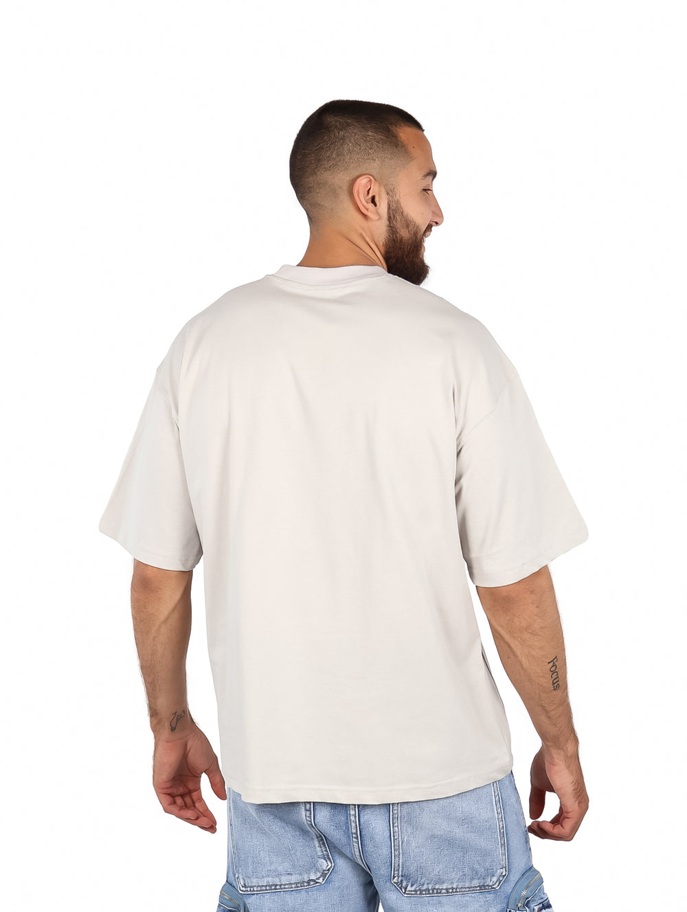 Hombre vistiendo una playera de manga corta color arena con corte relajado y cuello redondo.