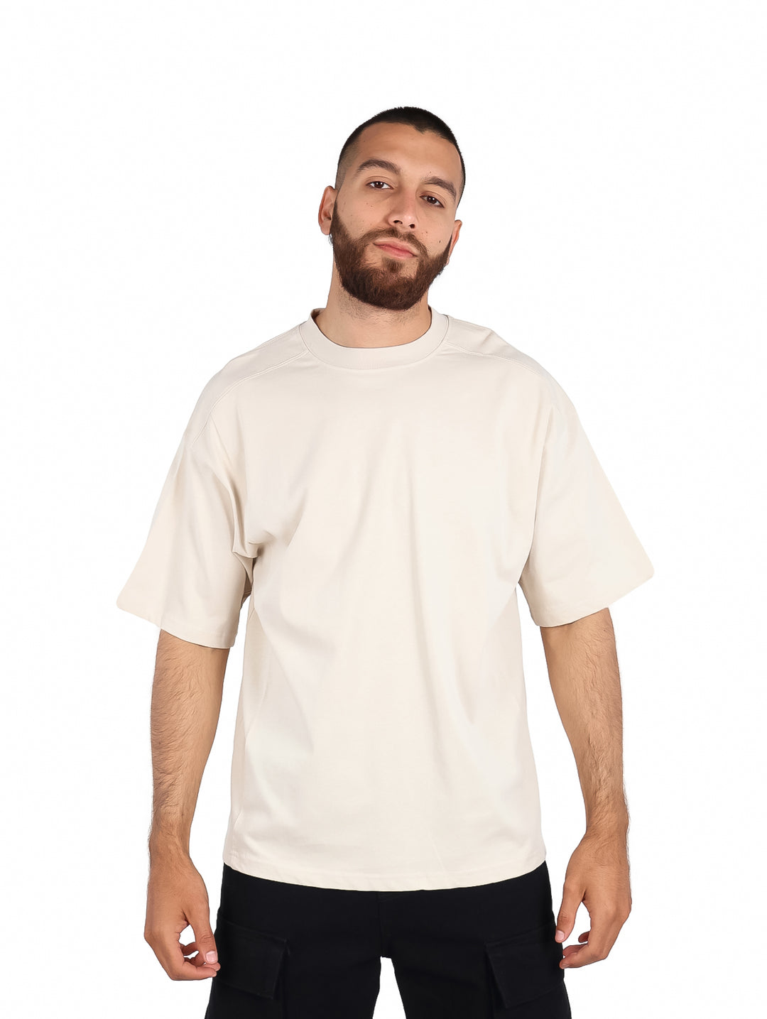 Hombre vistiendo una playera color beige de manga corta y cuello redondo.
