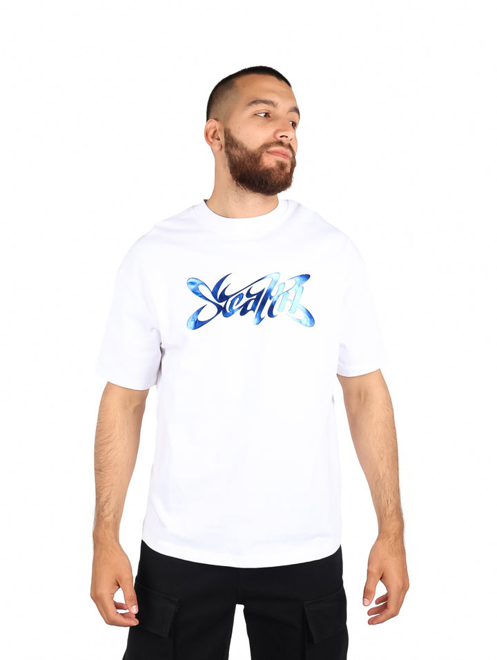 Hombre vistiendo playera blanca de manga corta con diseño gráfico azul en el pecho.