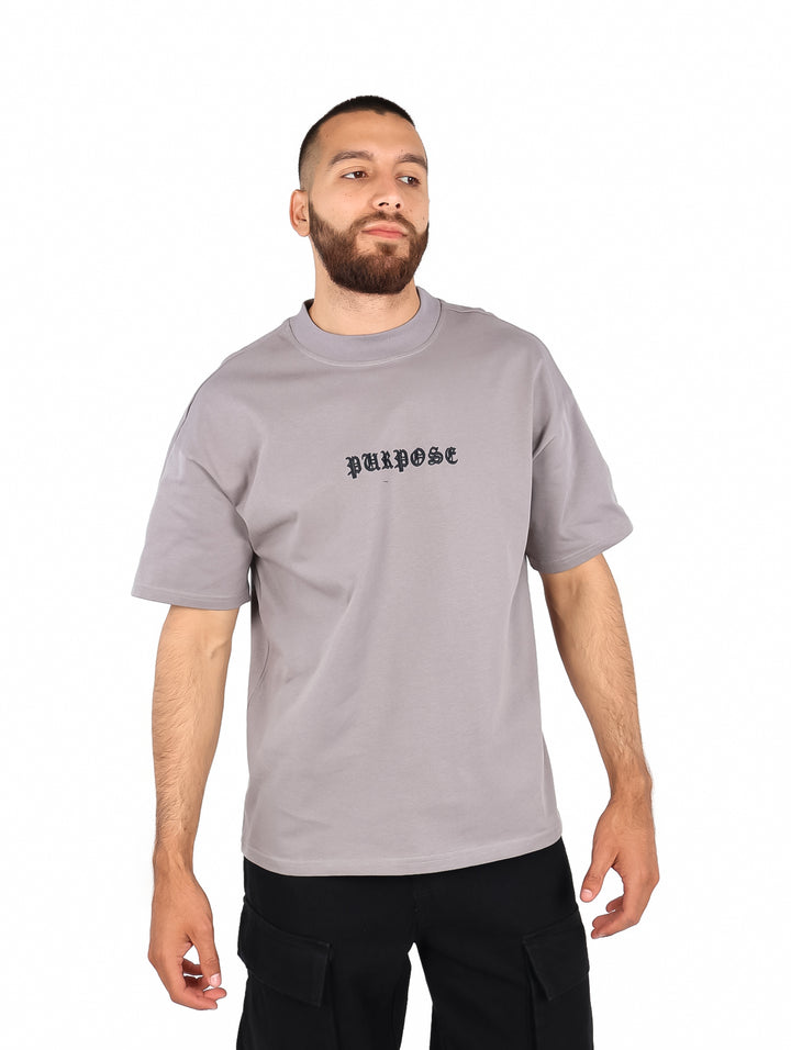 Hombre vistiendo playera color gris de manga corta con texto &