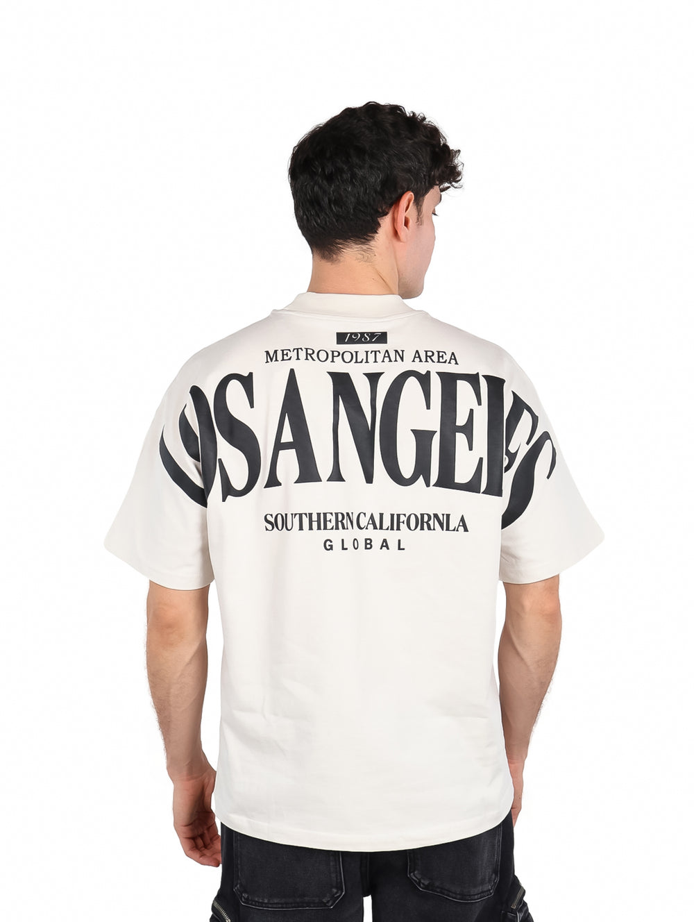 Hombre vistiendo una playera color beige con texto de Los Angeles en el pecho.