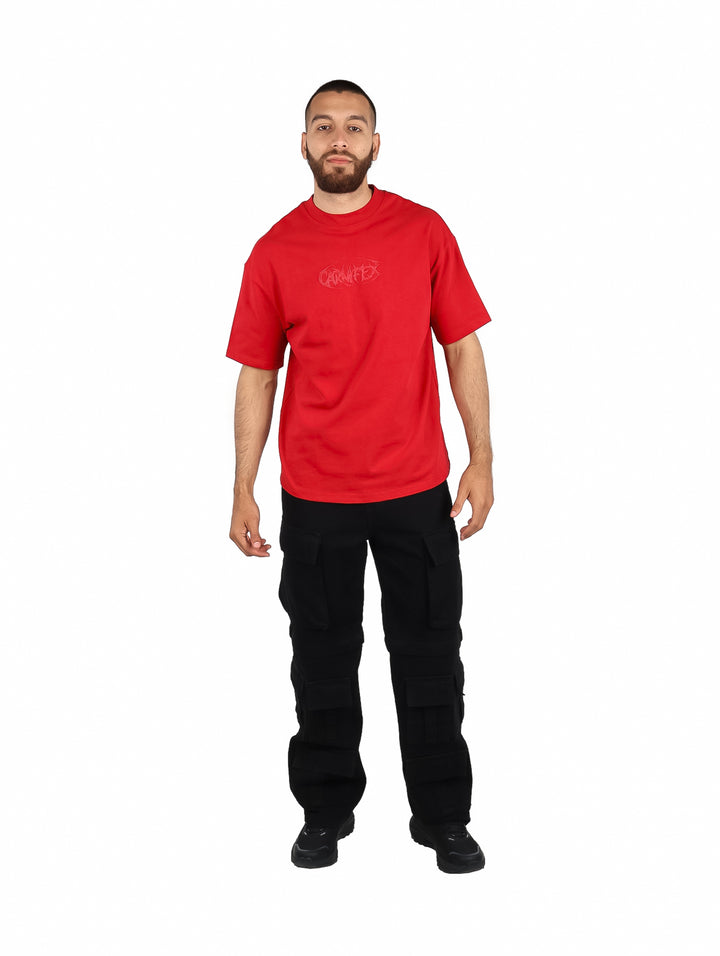 Hombre vistiendo una playera roja de manga corta con un diseño gráfico en el pecho.