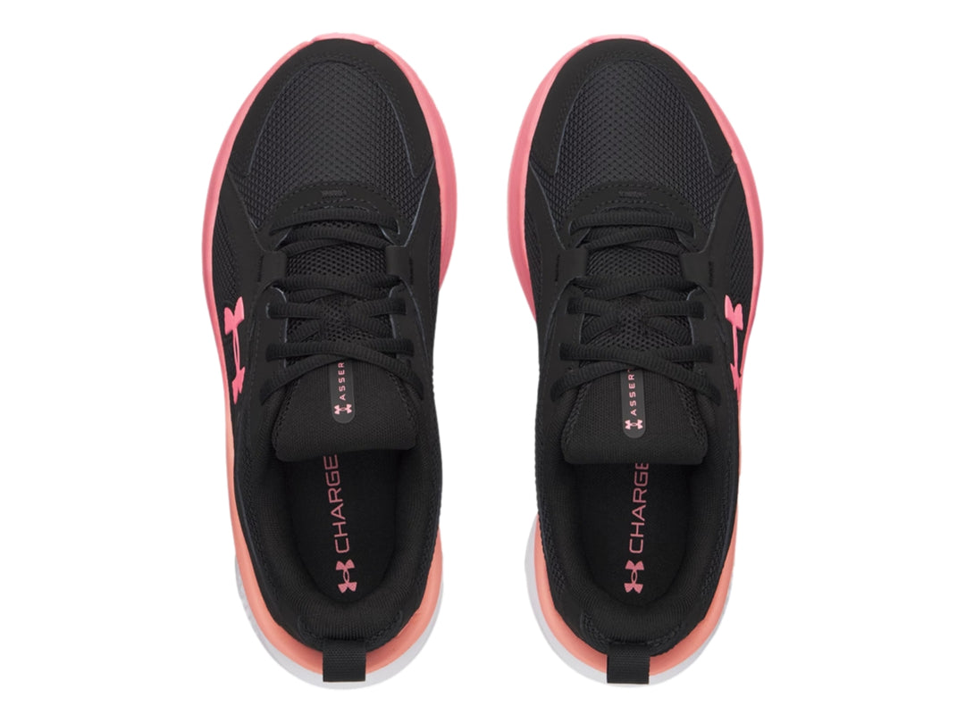 Tenis deportivos Under Armour en color negro con detalles en rosa y suela blanca.