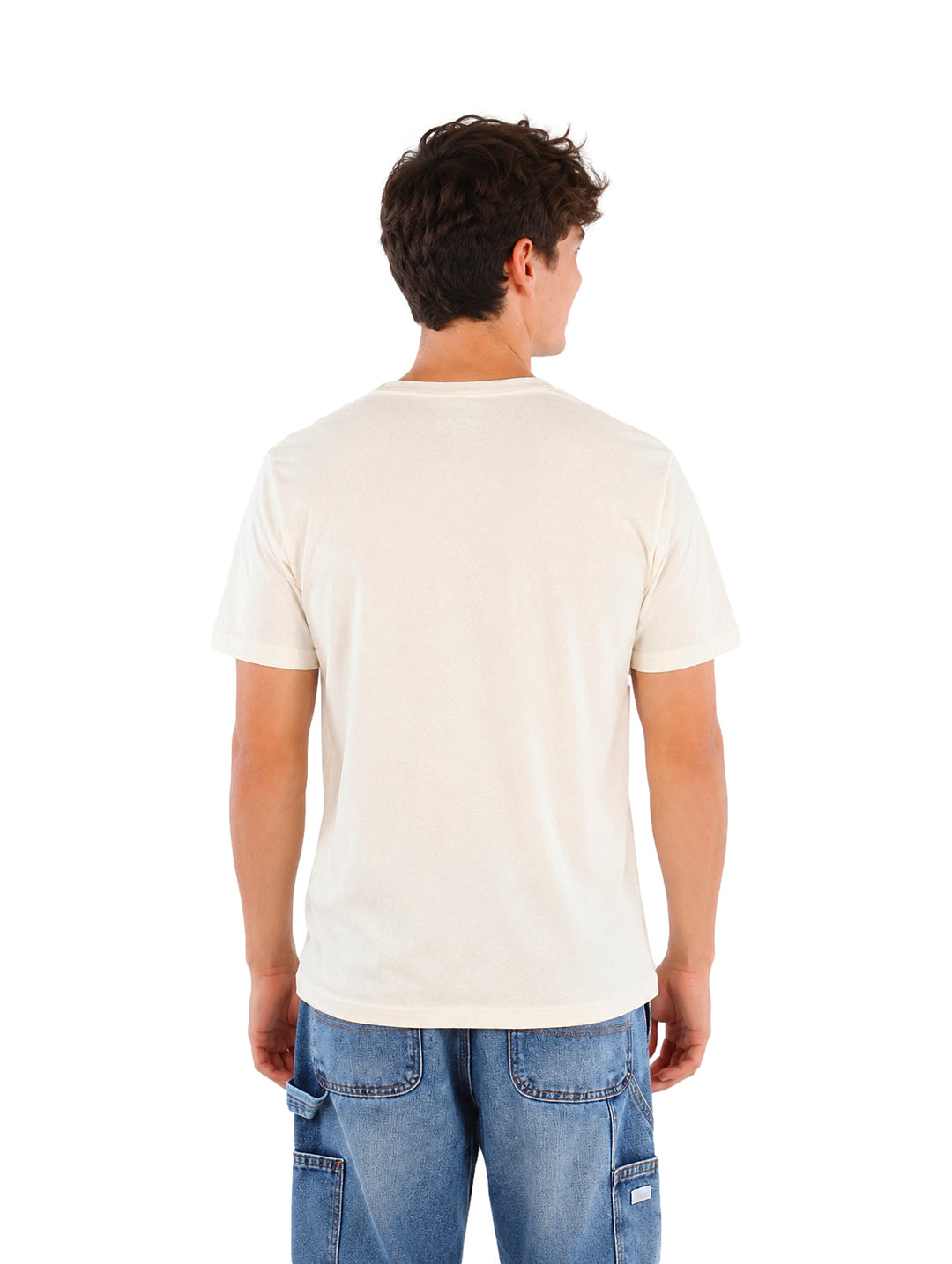 Hombre vistiendo playera color hueso con estampado de One Piece y jeans azules.