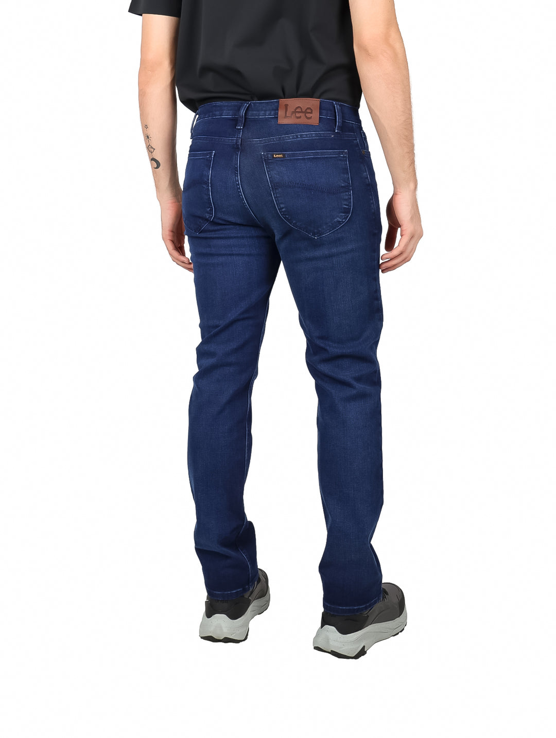 Hombre vistiendo pantalones jeans Lee de color azul oscuro.