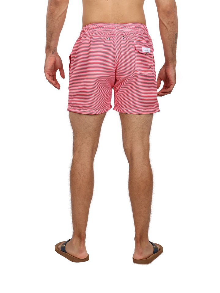 Hombre vistiendo un traje de baño corto con diseño de rayas horizontales en color rojo y blanco.