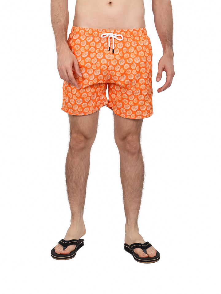 Hombre vistiendo un traje de baño corto color naranja con estampado blanco y cordón en la cintura.